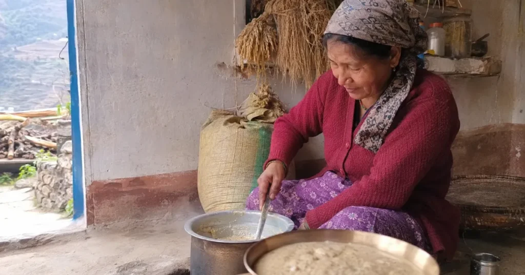 झंगोरे की खीर तैयार करती पहाड़ी महिला और पारंपरिक उत्तराखंडी रसोई का दृश्य