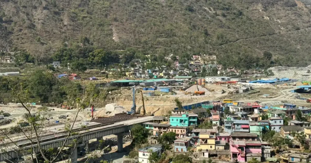 ऋषिकेश–कर्णप्रयाग रेल परियोजना के तहत पहाड़ी क्षेत्र में बनती सुरंग और रेल ट्रैक निर्माण कार्य, आसपास हिमालयी भूभाग और इंजीनियरिंग गतिविधि दिखाई देती हुई।
