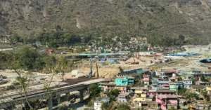 ऋषिकेश–कर्णप्रयाग रेल परियोजना के तहत पहाड़ी क्षेत्र में बनती सुरंग और रेल ट्रैक निर्माण कार्य, आसपास हिमालयी भूभाग और इंजीनियरिंग गतिविधि दिखाई देती हुई।