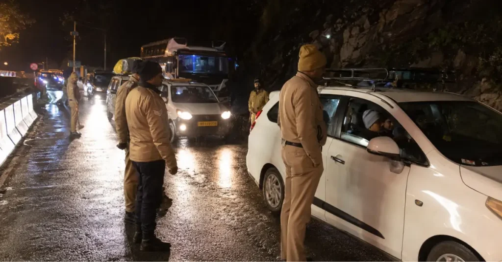 चारधाम यात्रा मार्ग पर रात के समय वाहनों की जांच करती पुलिस और रुकी हुई गाड़ियां