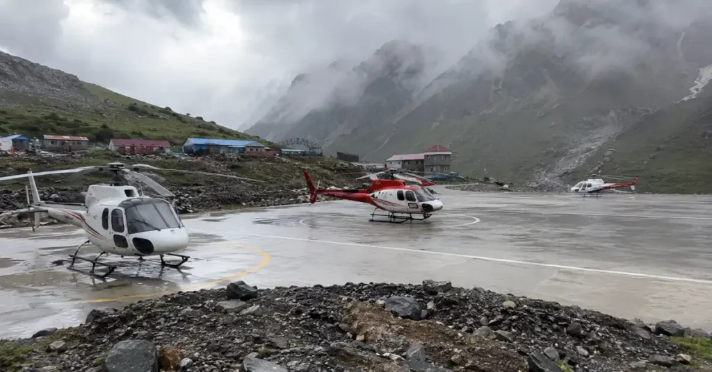 Helicopters stationed at a Himalayan helipad near Kedarnath during adverse monsoon weather conditions.