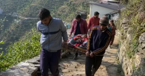 पहाड़ी क्षेत्र में बीमार व्यक्ति को स्ट्रेचर के सहारे अस्पताल तक ले जाते ग्रामीण