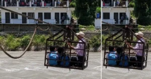 Schoolchildren and a guardian crossing the Ramganga River in a manually operated trolley after the bridge was washed away in Bageshwar.