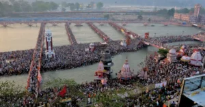 Aerial view of thousands of pilgrims gathered at Har Ki Pauri during the Haridwar Kumbh, with bathing ghats and pontoon bridges across the Ganga.