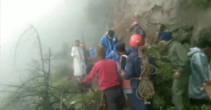Rescue personnel and officials assist pilgrims along a landslide-affected section of the Kedarnath foot route during monsoon conditions.