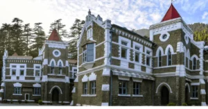 The historic Uttarakhand High Court building in Nainital surrounded by deodar trees.
