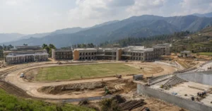 Representative image of a modern sports college campus with academic buildings, athletics track and sports infrastructure in a Himalayan setting.